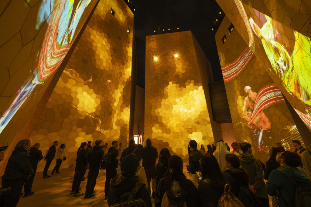 Visitors beneath projection-mapped walls inside the Saudi Arabia Pavilion at Expo 2025 Osaka.