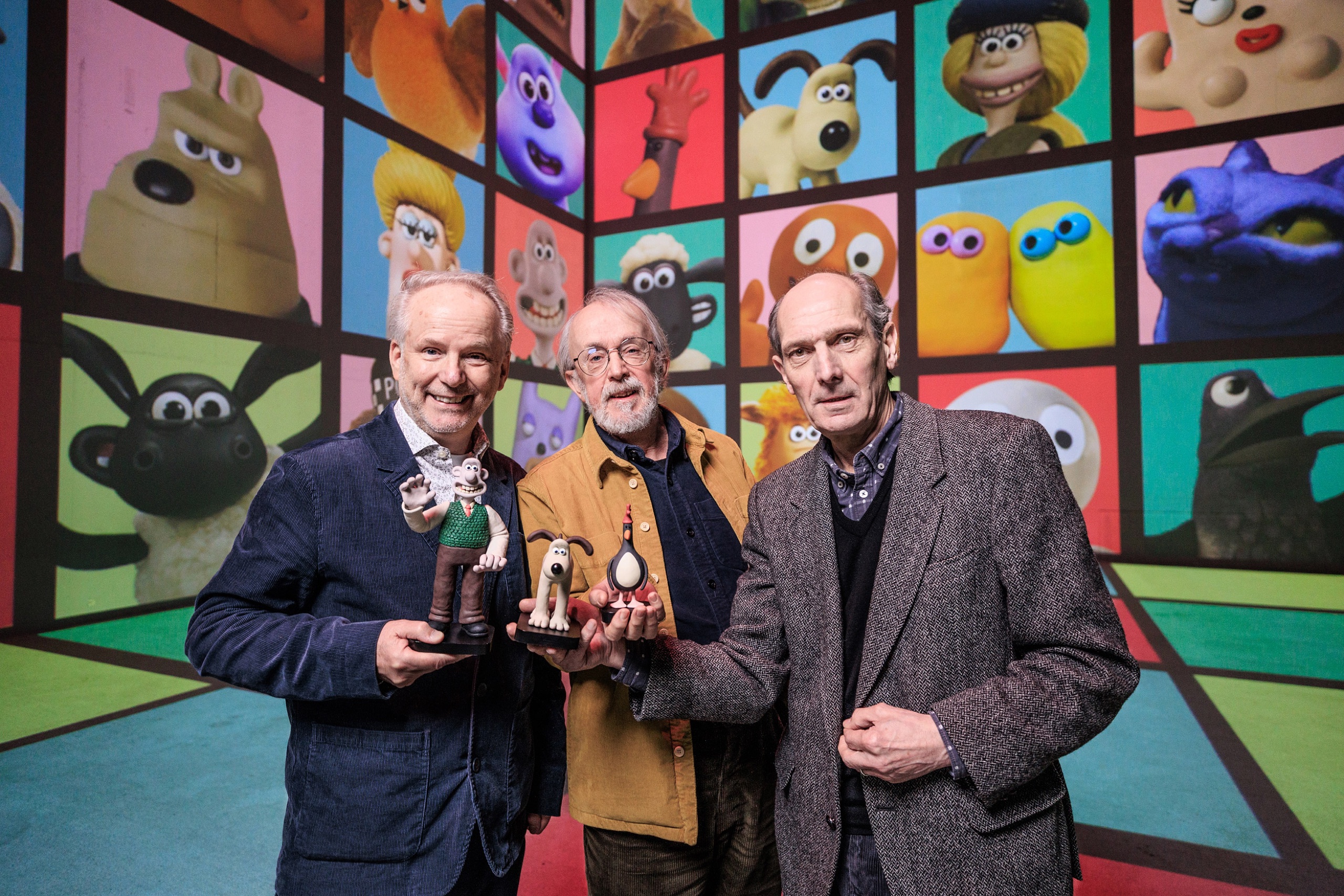 Aardman's Nick Park, Peter Lord and David Sproxton holding their characters inside the Aardman immersive experience at Lightroom