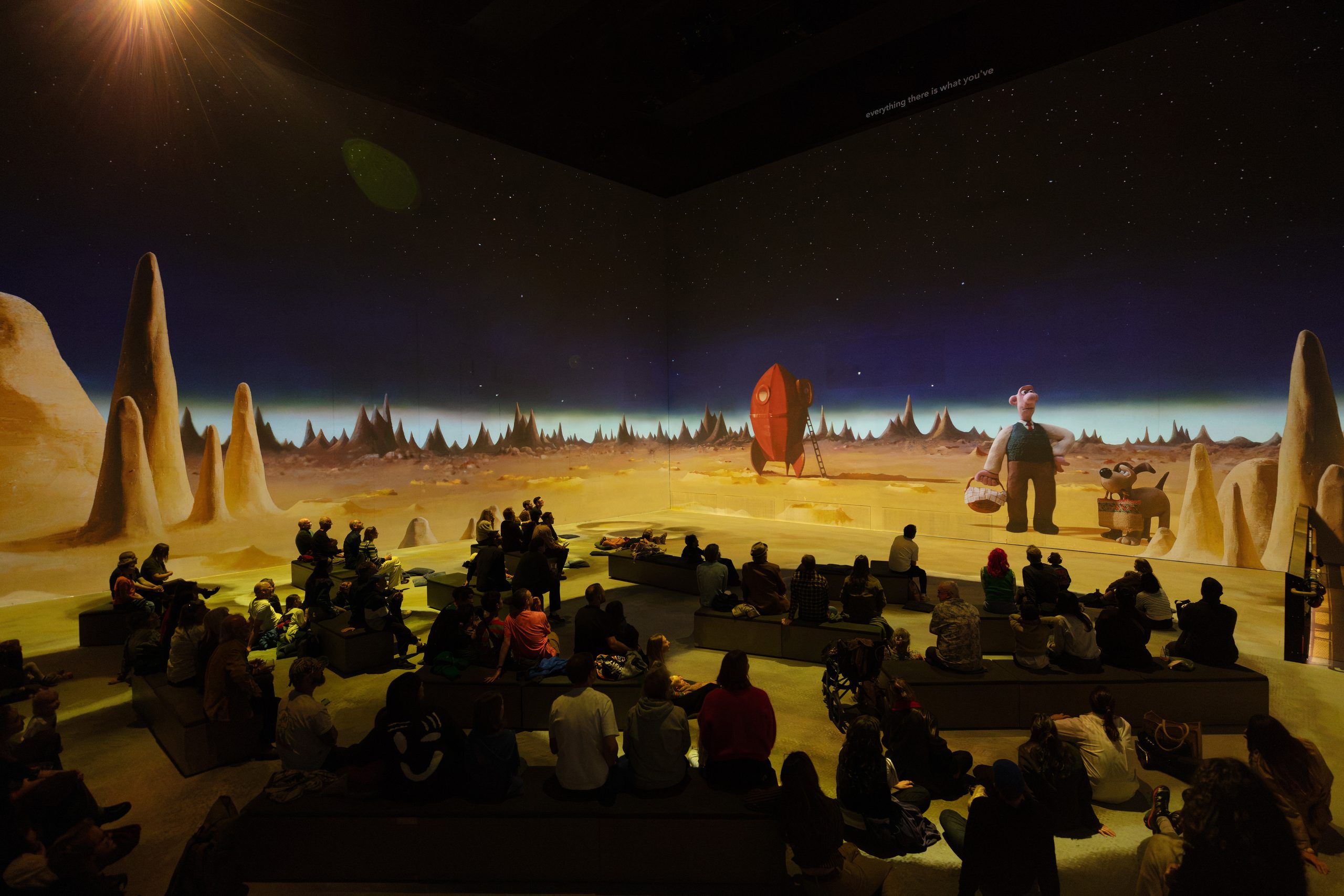 Audiences seated across a projected lunar landscape from Wallace & Gromit: A Grand Day Out