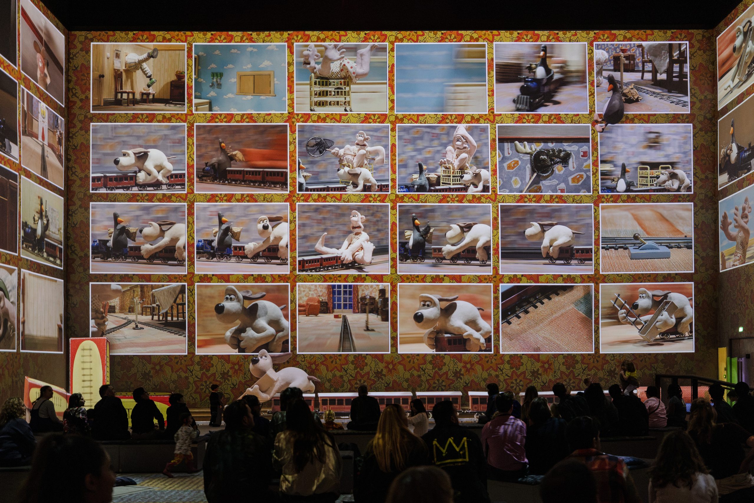 Film stills from the Wallace & Gromit: The Wrong Trousers train chase fill Lightroom’s walls in the Aardman immersive experience
