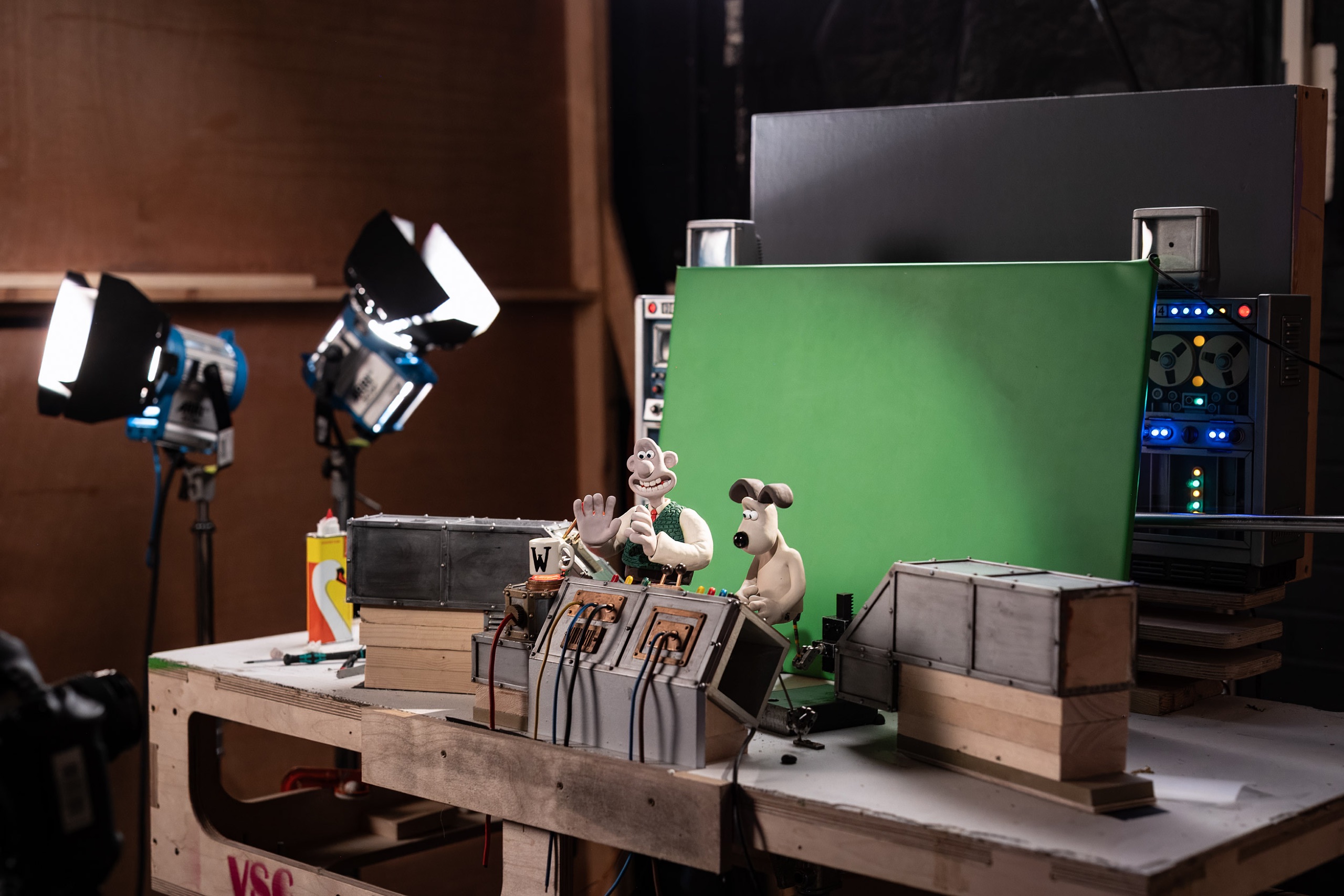 A miniature Wallace & Gromit set lit for stop-motion filming in front of a green screen at Aardman