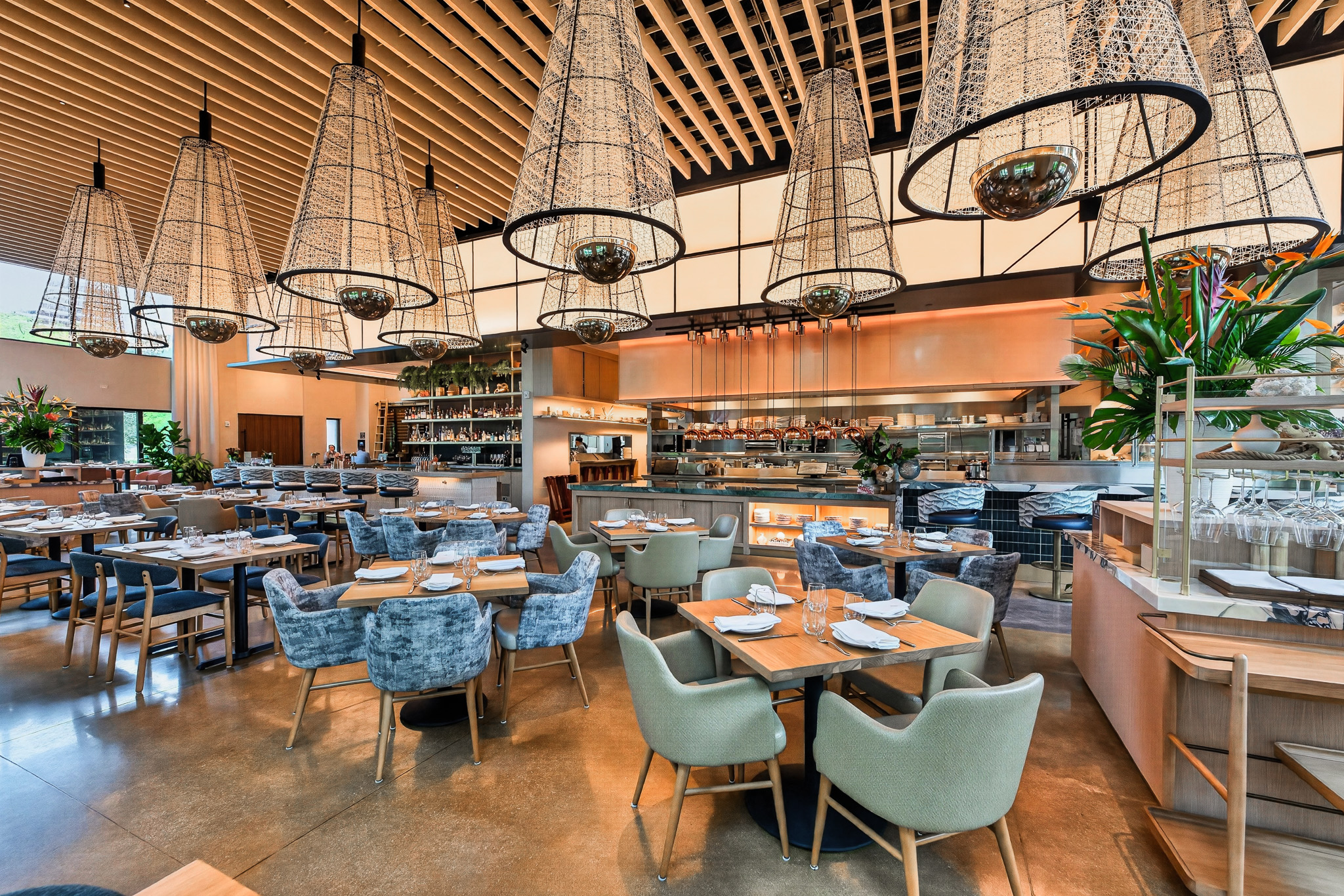 The expo kitchen and gantry at the heart of the restaurant, framed by oversized conical pendants above the dining room